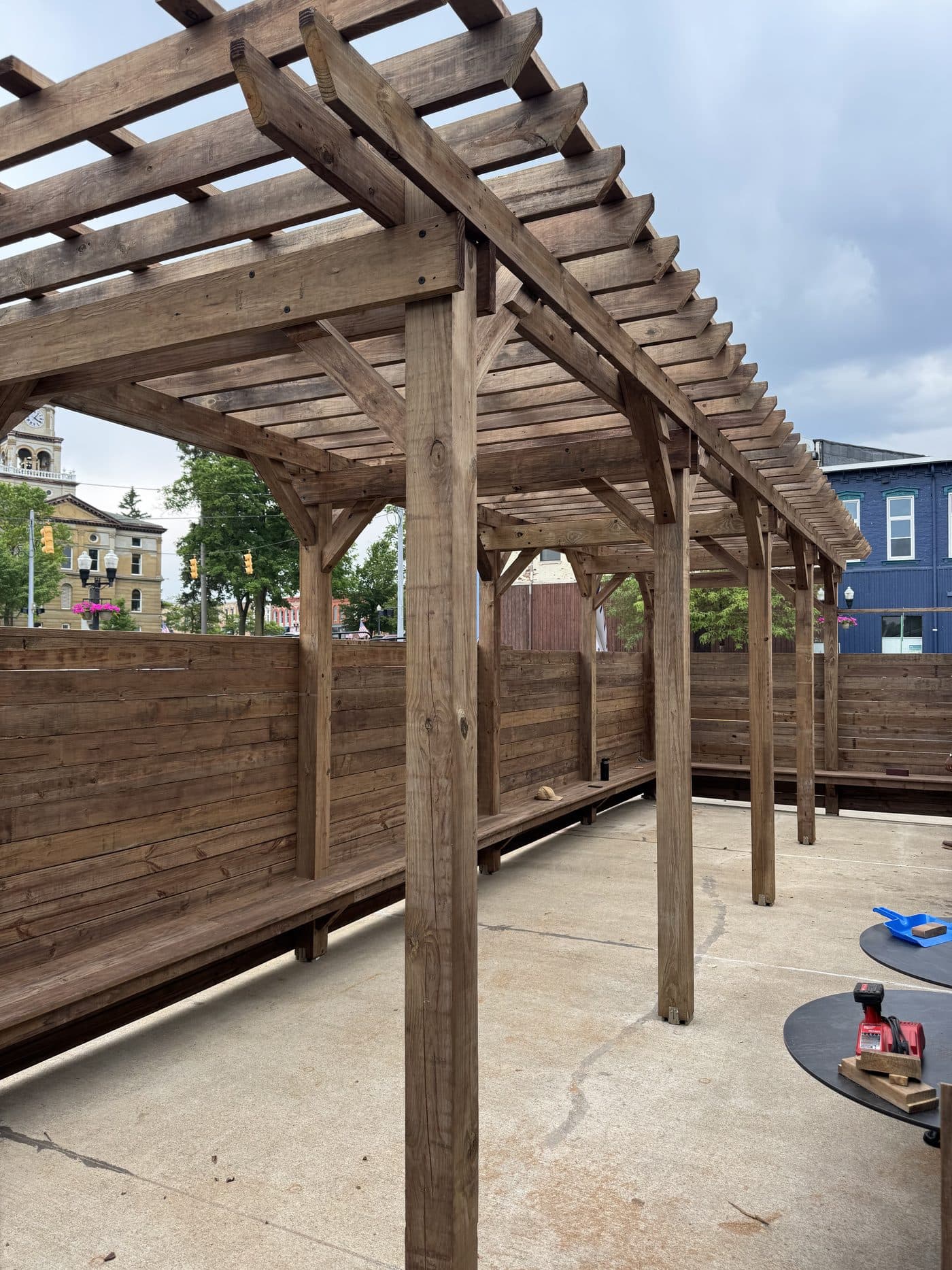 Open-rafter pergola shading a wood-framed patio seating area